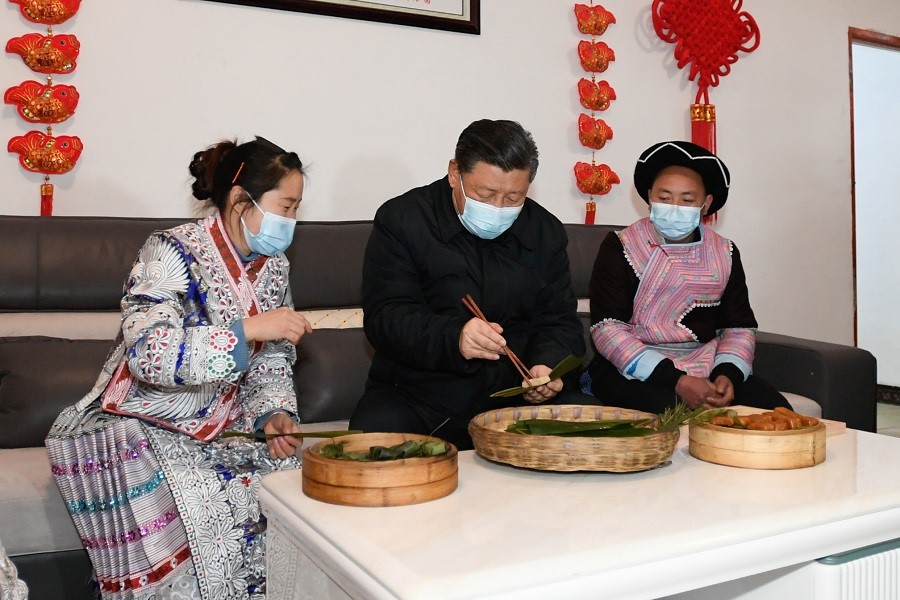 2021年2月3日下午，習(xí)近平在貴州畢節(jié)市黔西縣新仁苗族鄉(xiāng)化屋村苗族村民趙玉學(xué)家，同一家人邊聊家常邊制作當(dāng)?shù)貍鹘y(tǒng)節(jié)日食品黃粑。新華社記者 李學(xué)仁 攝