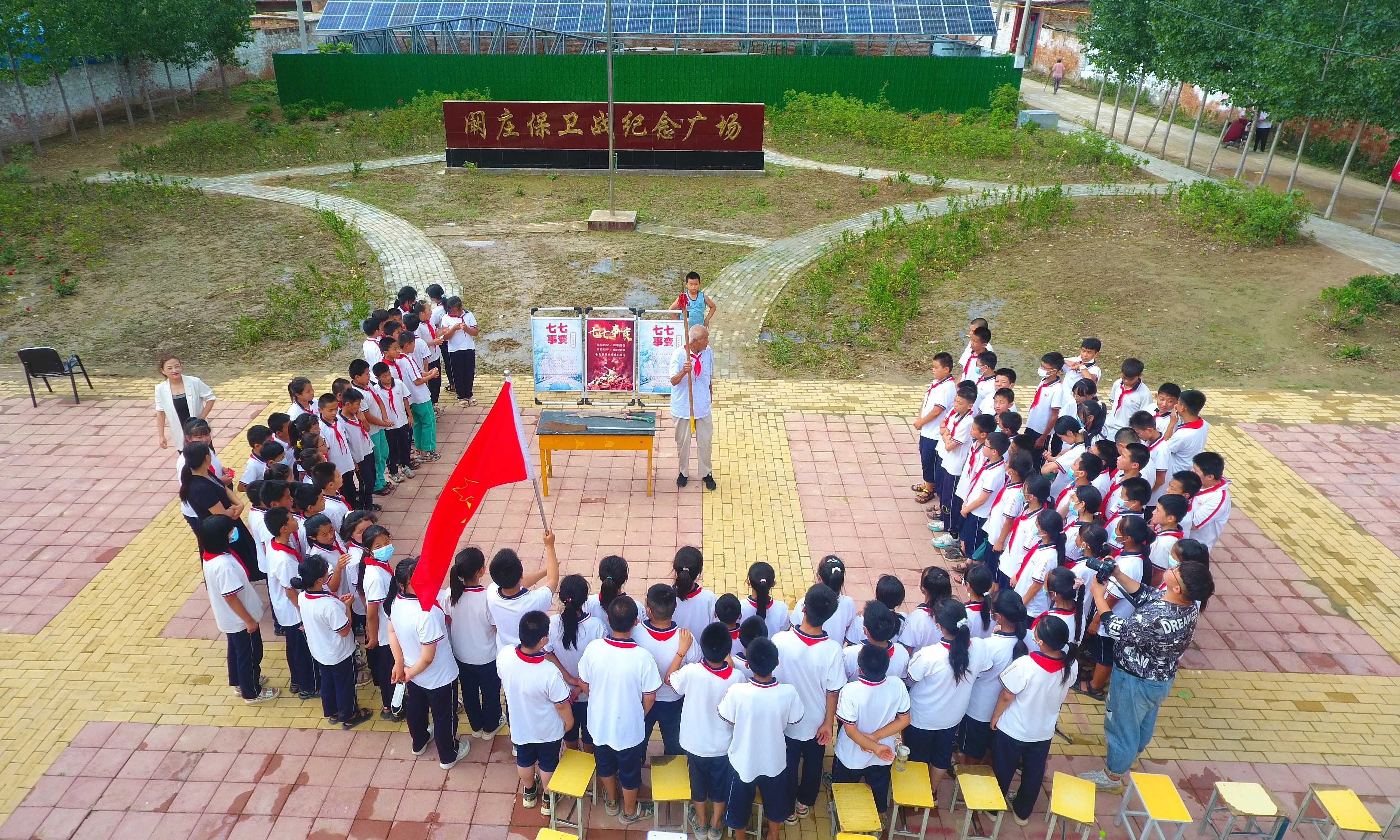 2022年7月6日，山東省聊城市，在茌平區(qū)菜屯鎮(zhèn)闞莊村的闞莊保衛(wèi)戰(zhàn)紀(jì)念廣場(chǎng)，闞莊保衛(wèi)戰(zhàn)親歷者王光木老人，為小學(xué)生們講述抗戰(zhàn)故事，展示大刀、長(zhǎng)矛。