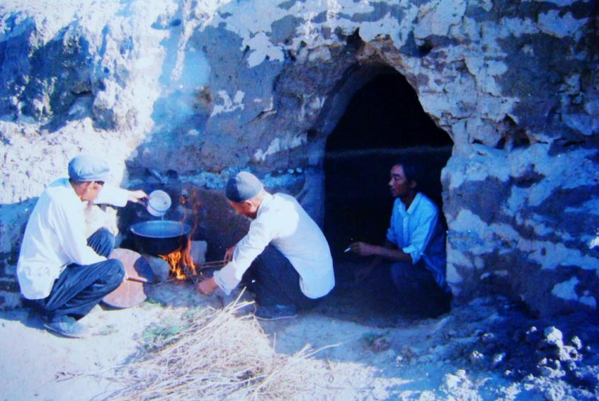 1983年，“六老漢”一代治沙人在“地窩子”生活做飯。新華社發(fā)（八步沙林場(chǎng)供圖）